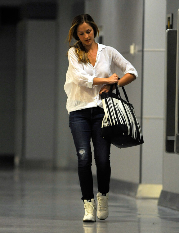 Coach Minka Kelly carries a Coach x Krink Weekend Tote at LAX